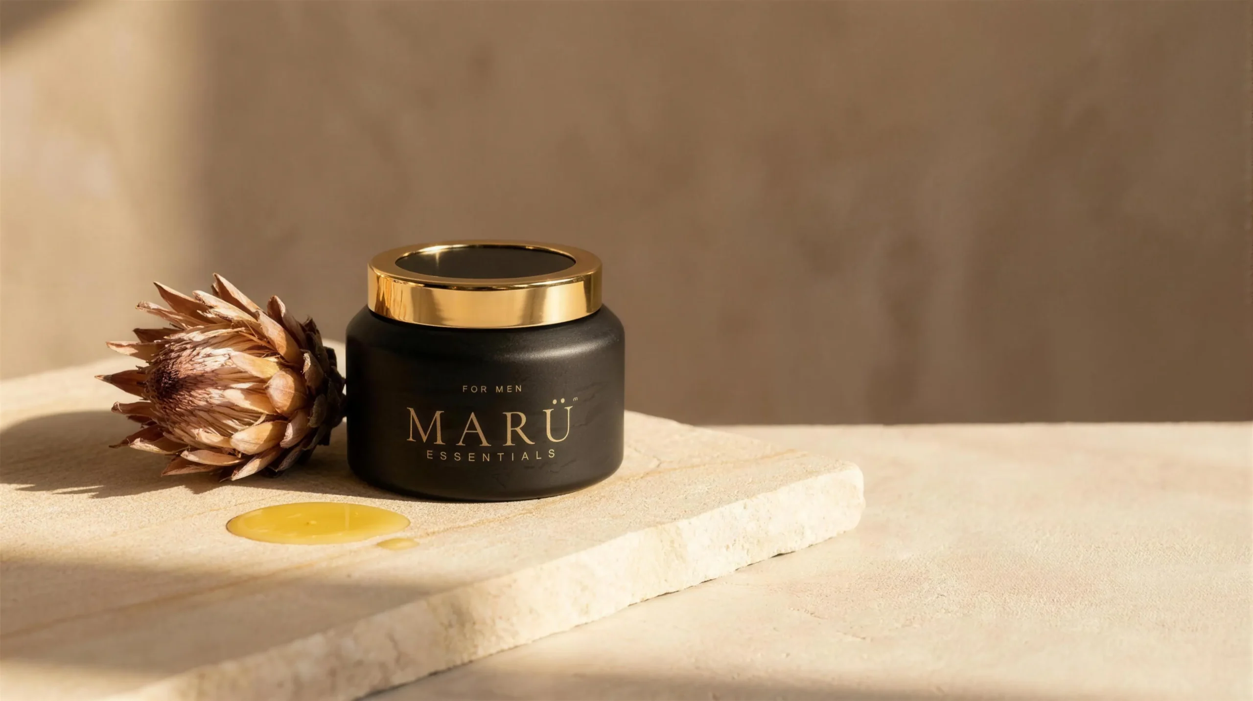 MARÜ ESSENTIALS jar on pale stone beside a dried protea and golden oil in warm afternoon light